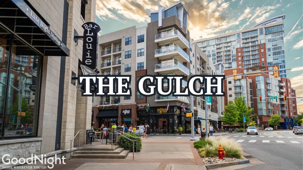 Modern apartment buildings line a lively street scene anchored by the Bar Louie sign. People walk along the sidewalks, enjoying outdoor dining and a social, energetic urban environment as sunset approaches.