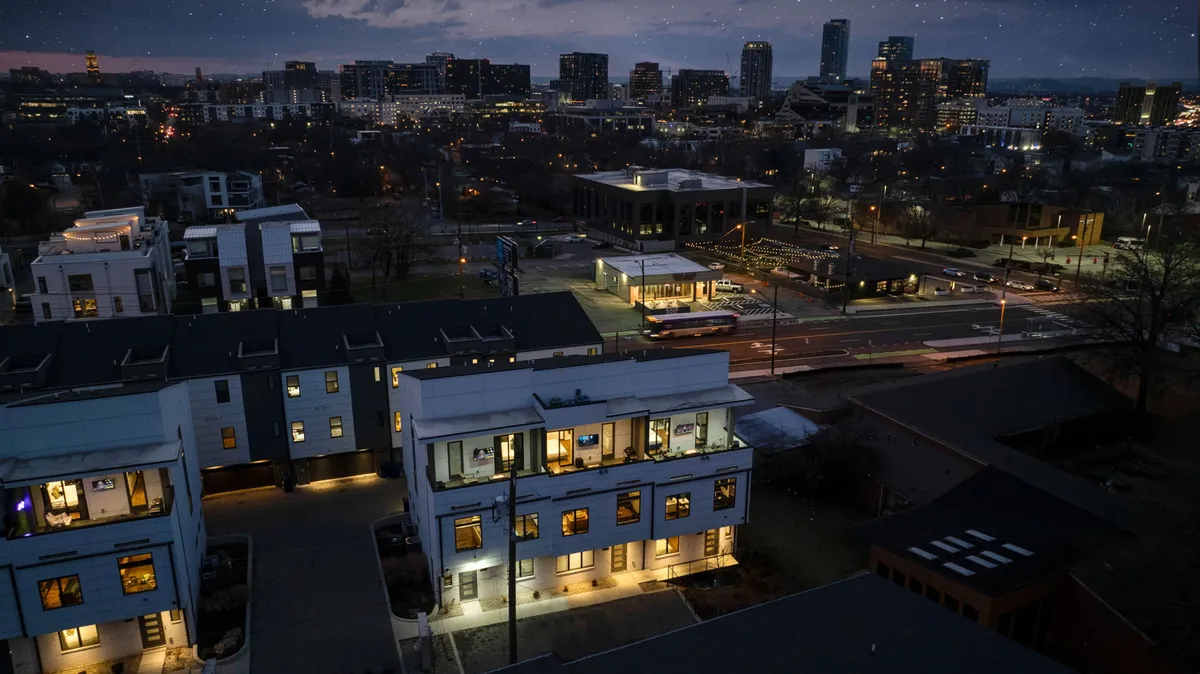 A lively nighttime cityscape featuring illuminated buildings, streetlights, and cars, viewed from an elevated perspective. The image suggests the vibrant buzz of Nashville nights, ideal for capturing the energy and group experience from a rooftop vantage point.